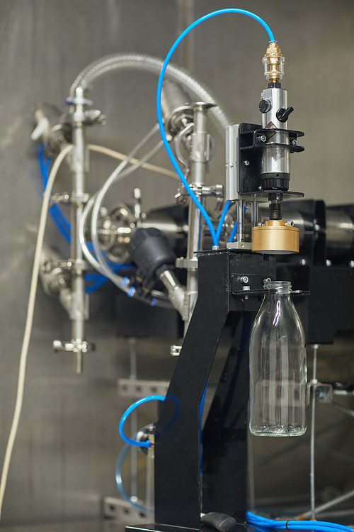 Vertical background image of bottle filling machine at food factory, copy space