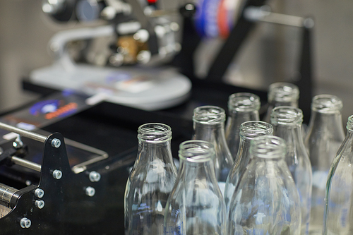 Close up background image of bottles at conveyor belt at food factory, copy space