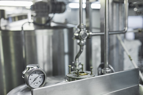 Close up background image of pressure gauge and connection rods at barrels at industrial production plant, copy space