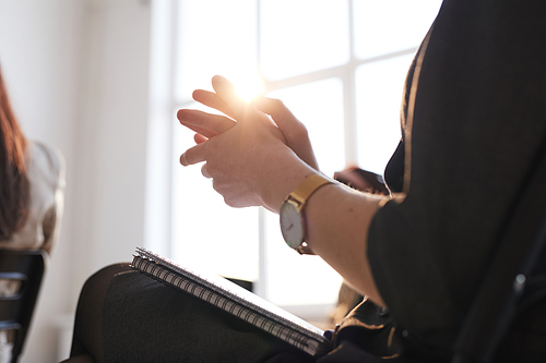 Close up of people sitting in row at business conference, focus on female hands applauding with lens flare, copy space