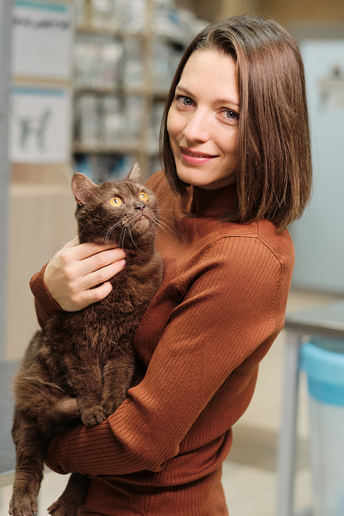 Portrait of young woman looking at camera and holding her beautiful cat