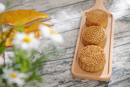 Wooden board with homemade mooncake prepared for mid autumn festival, selective focus