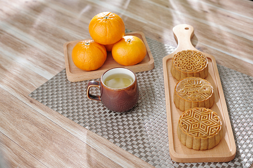 Cup of herbal tea, moon cake and tangerines served for traditional festival