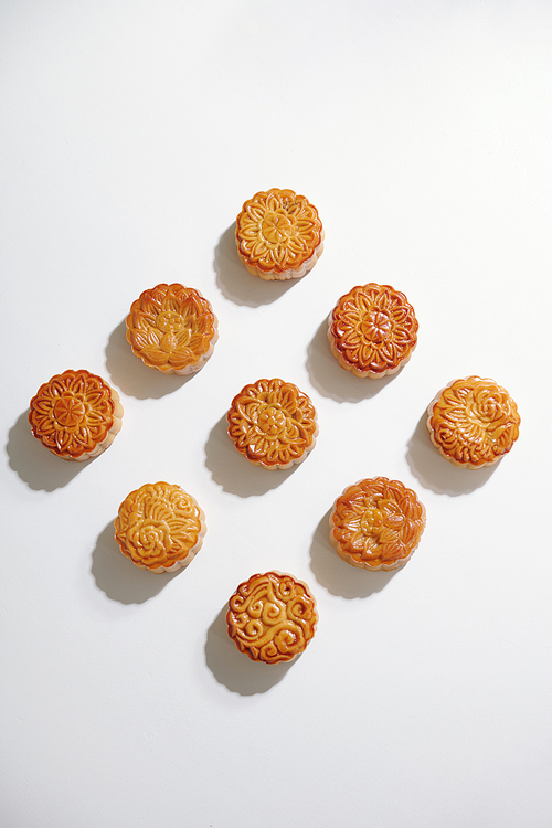 Nine beautiful decorated moon cakes on white background, view from the top