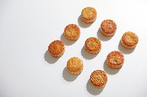 Delicious mooncakes prepared for mid fall festival on white table, view from above