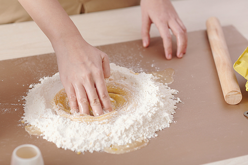 Hands of woman making circle motion to mix liquid and dry ingredients for mooncake dough
