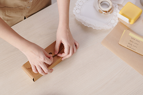 Hands of woman closing carboard box with homemade mooncakes, view from above