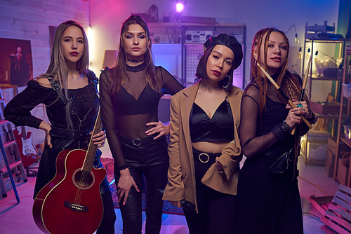 Row of contemporary female musicians standing in studio of sound records