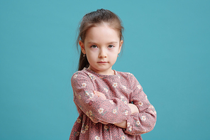 Cute Caucasian little girl looking at you seriously