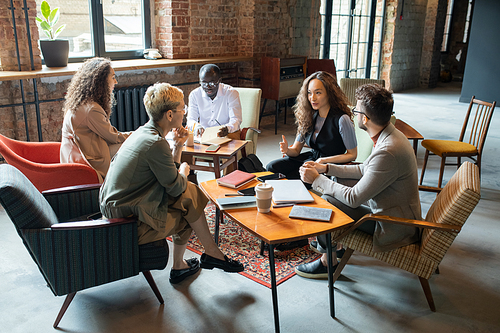 Young businesswoman explaining her colleagues one of working points at meeting