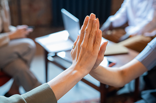 Two businesswomen making high-five gesture in working environment