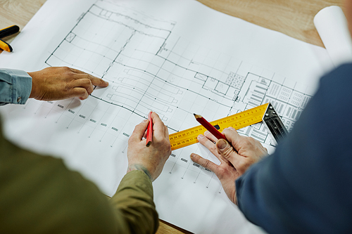 Top view close up of two architects discussing floor and furniture plans, copy space