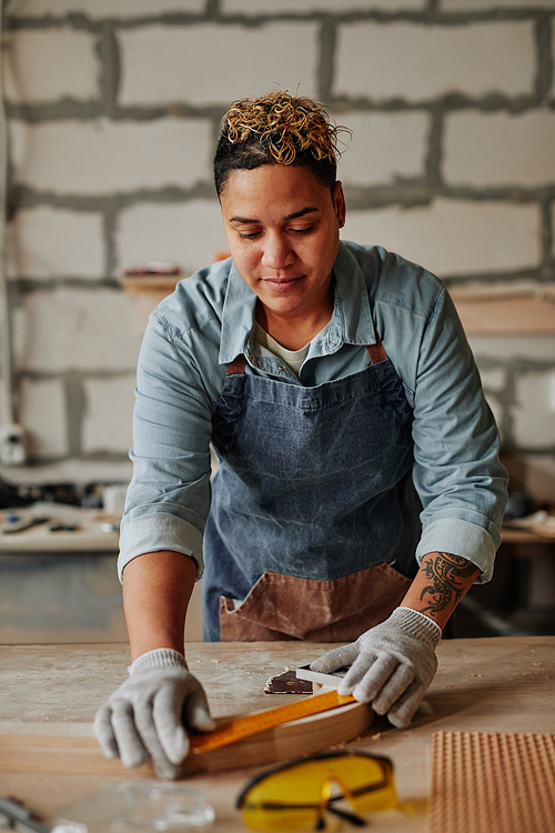 Warm toned portrait of inspired female artisan building handmade furniture pieces in workshop, copy space