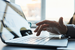 Close up of male hand pressing laptop key with data on screen, copy space