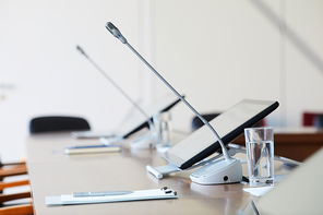 Image of empty table with computer and microphone at conference room