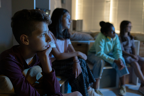 Contemporary schoolchildren watching movie at lesson in dark room