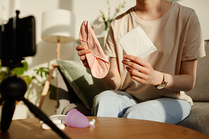 Minimal closeup of young woman holding pads to camera and filming educational video on feminine hygiene products