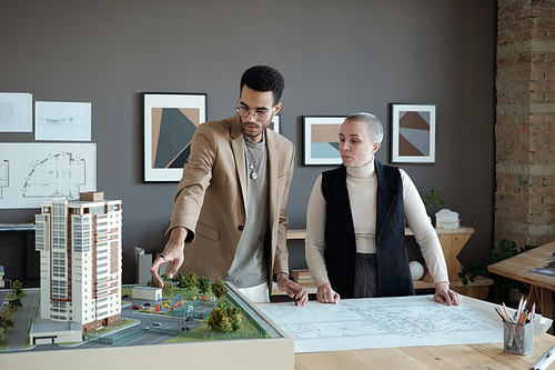 Two professional engineers and architects discussing house layout while one of them making presentation of new project