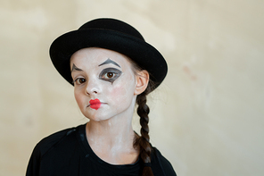 Cute serious girl with halloween makeup looking at you against white background