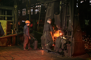 Worker in protective workwear operating at the metallurgical plant