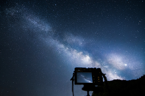밤하늘 은하수를 촬영하고 있는 카메라와 삼각대