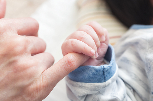 아빠 혹은 엄마의 새끼손가락을 아기의 손으로 꼭쥐고 있는 모습