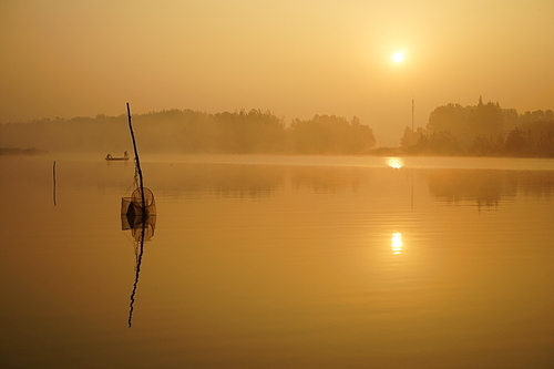 The calm lake in the pale morning mist, the sun just rising, the fisherman and a peaceful heart!