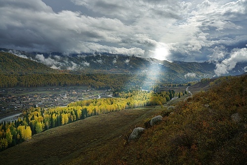 Walking on the ridge of the grasses, the rain began to clear after the rain, and suddenly a beam of light pierced the clouds and caught the moment