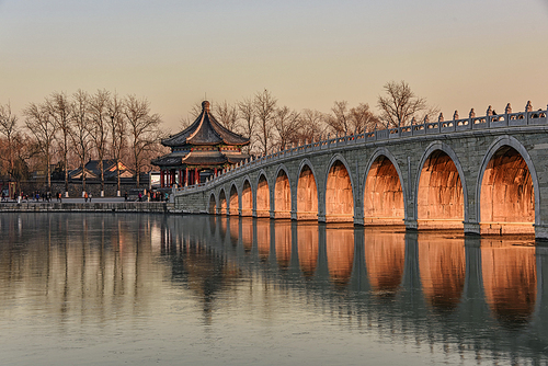 Around the winter solstice, the 17-hole bridge of the Summer Palace is brightened by the setting sun, and the golden light is perforated into a beautiful landscape.