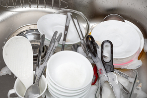 주방에 쌓여 있는 그릇들을 깨끗이 설거지 하다
