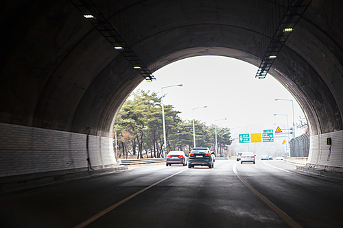 자동차도로의 터널을 지나는 승용차들