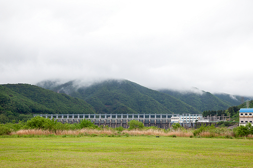 구름낀 산을 배경으로한 웅장한 댐