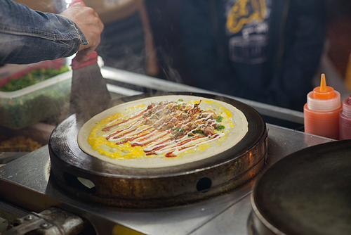 Cook making street food with meat and various sauces