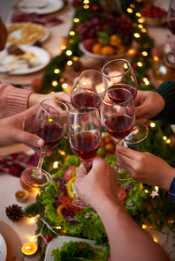 Group of people celebraiting New Year. They are drinking red wine