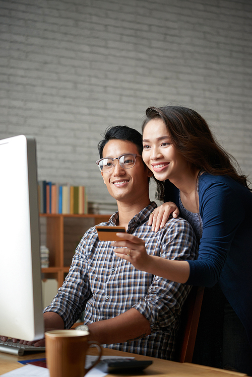 Beautiful young Asain couple choosing items to buy online