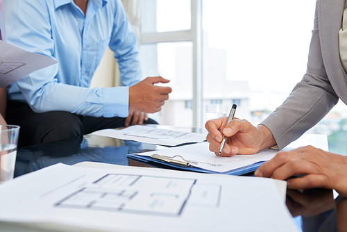 Hands of broker writing down every wish of her client