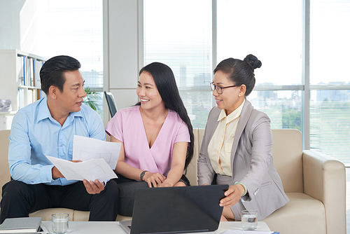 Vietnamese couple and estate agent discussing different apartments plans