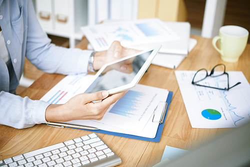 Digital tablet in hands of female financial manager