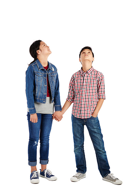 Children holding hands and looking-up, isolated on white