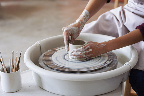 Hands of clay potter working on new product