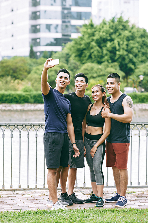 Vietnamese sporty young people smiling and taking selfie together