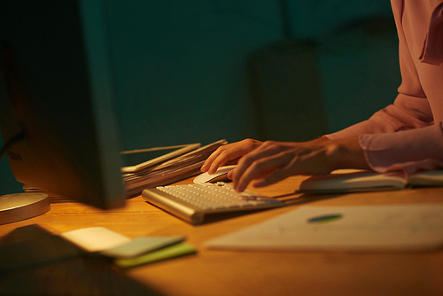 Hands of business lady working on computer late at night