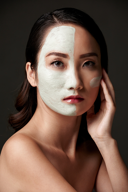 Pretty woman with rejuvenating clay mask on her face