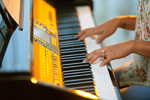 Hands of female pianist practicing at home