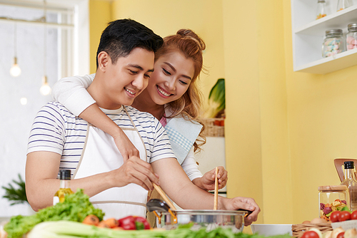 Young Vietnamese couple in love cooking together