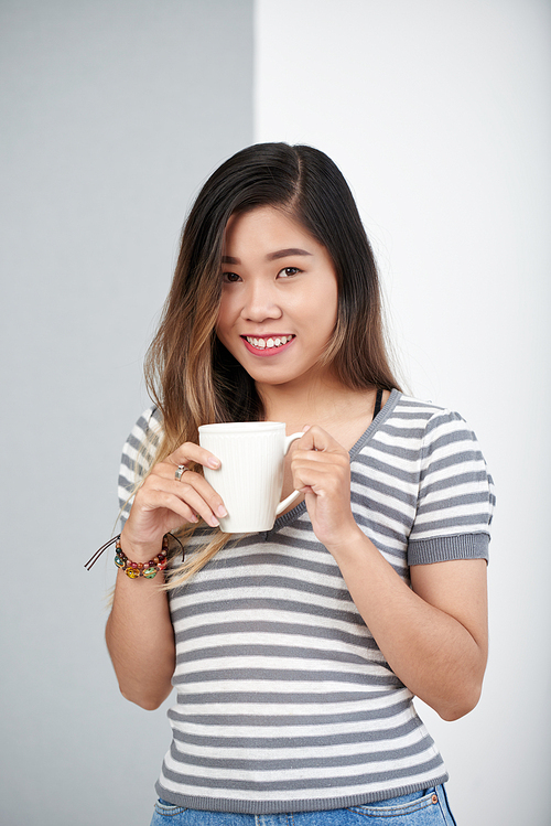 Portrait of beautiful Asian teenage girl drinking coffee