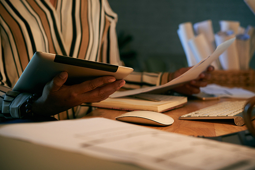 Documents and digital tablet in hands of business lady