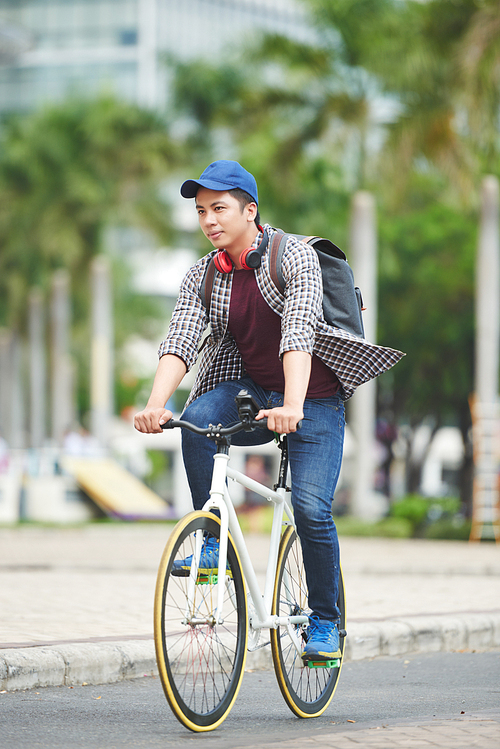 Asian young man riding fixie bicycle in the street