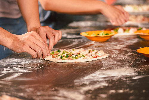 Hands of person making pizza at master-class