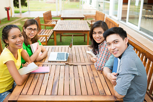 Vietnamese student sitting at table on campus after studying